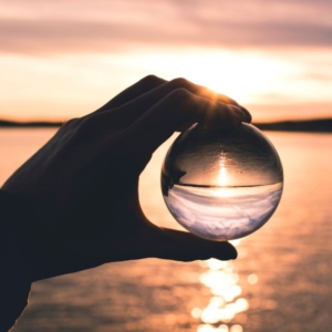 a psychic reader holding a crystal ball in the sunset