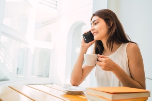 a female on the phone to a psychic reader whilst holding a cup of coffee