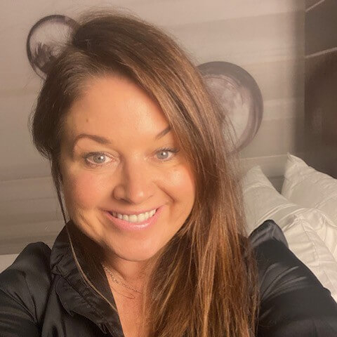 A woman smiling taking a selfie.